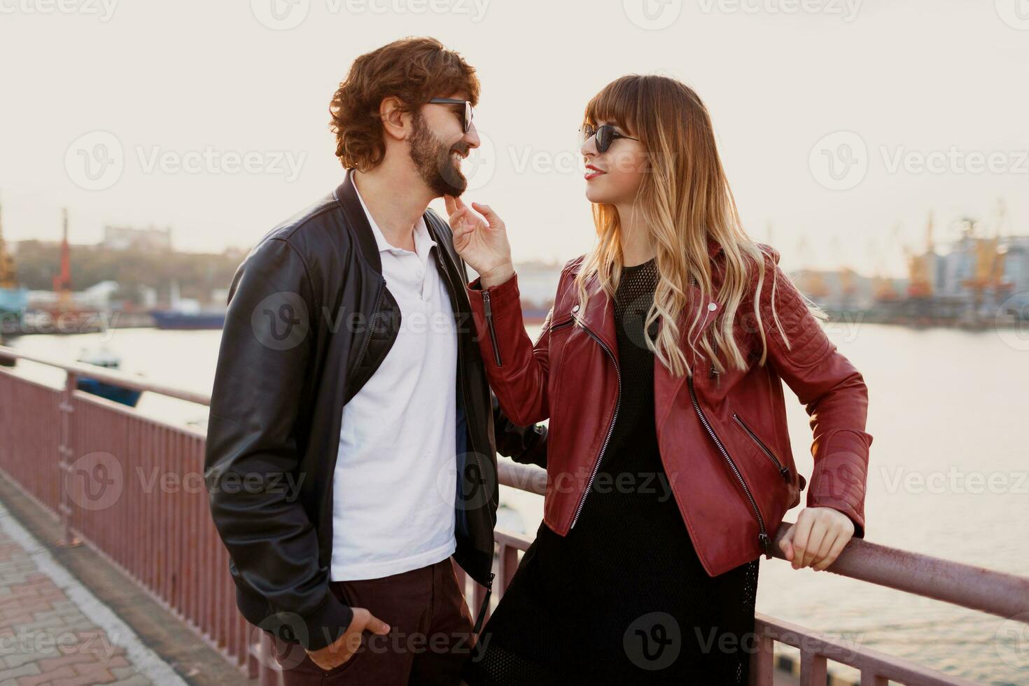 Romantic moments of stylish couple in love having a conversation and enjoying the time spend with each other . Handsome man with his wife walking on the bridge. photo