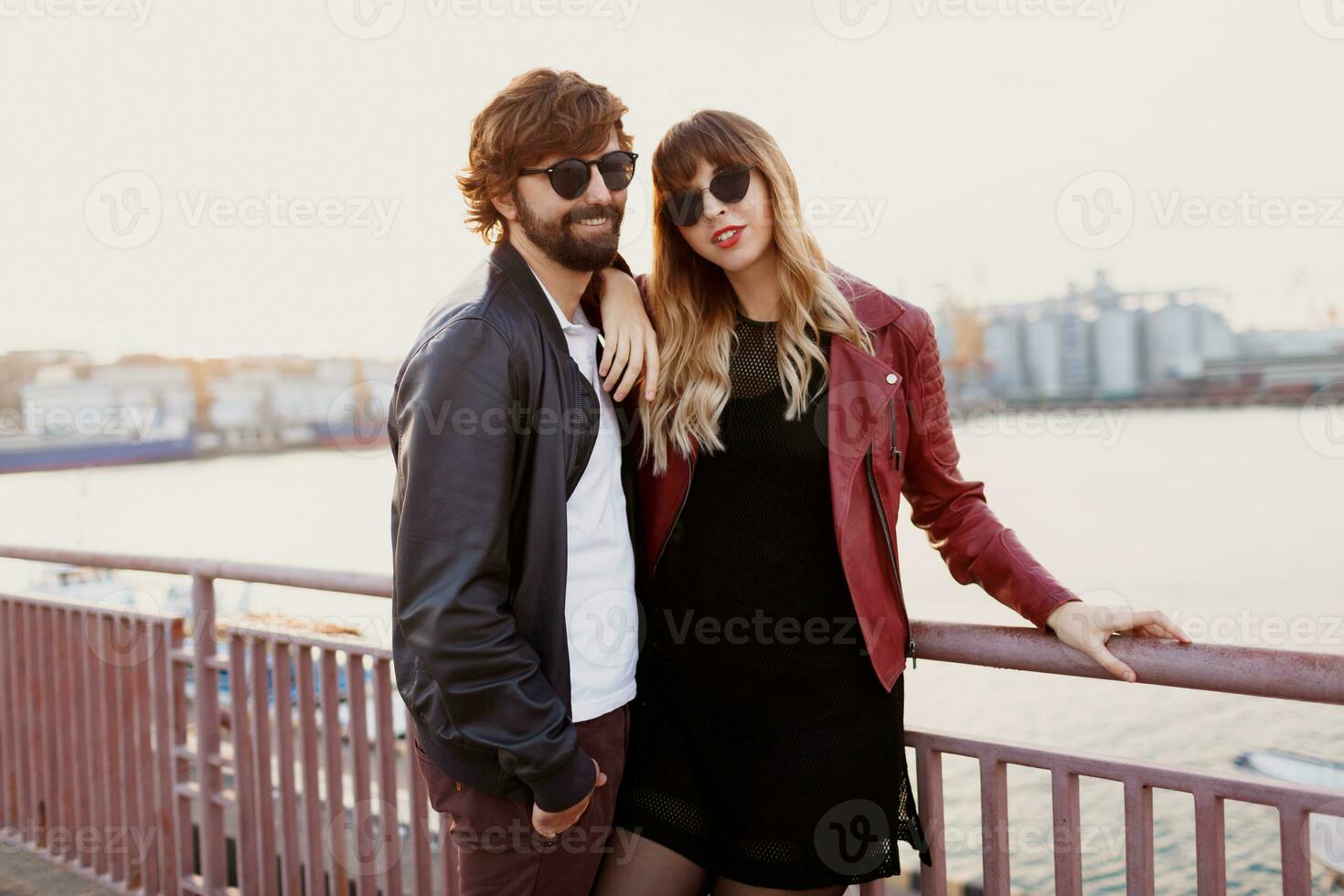 Romantic moments of stylish  couple in love having a conversation and enjoying the time spend with each other . Handsome man with his wife walking on the bridge. photo