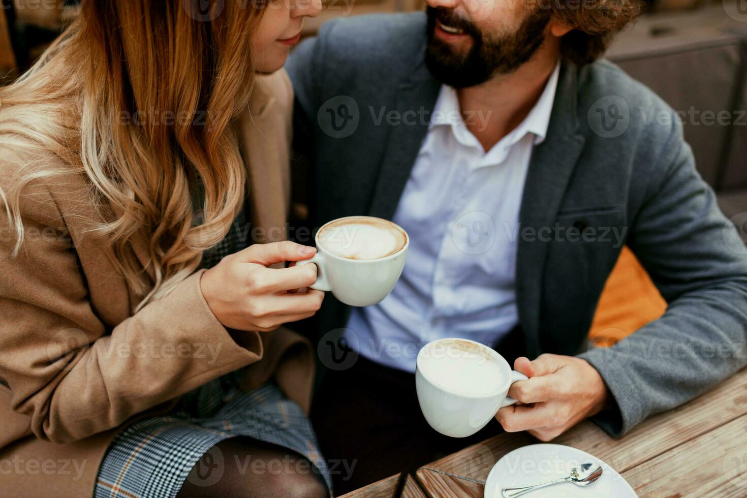 elegante Pareja en amor sentado en un cafetería, Bebiendo café, teniendo un conversacion y disfrutando el hora gastar con cada otro. selectivo atención en taza. foto