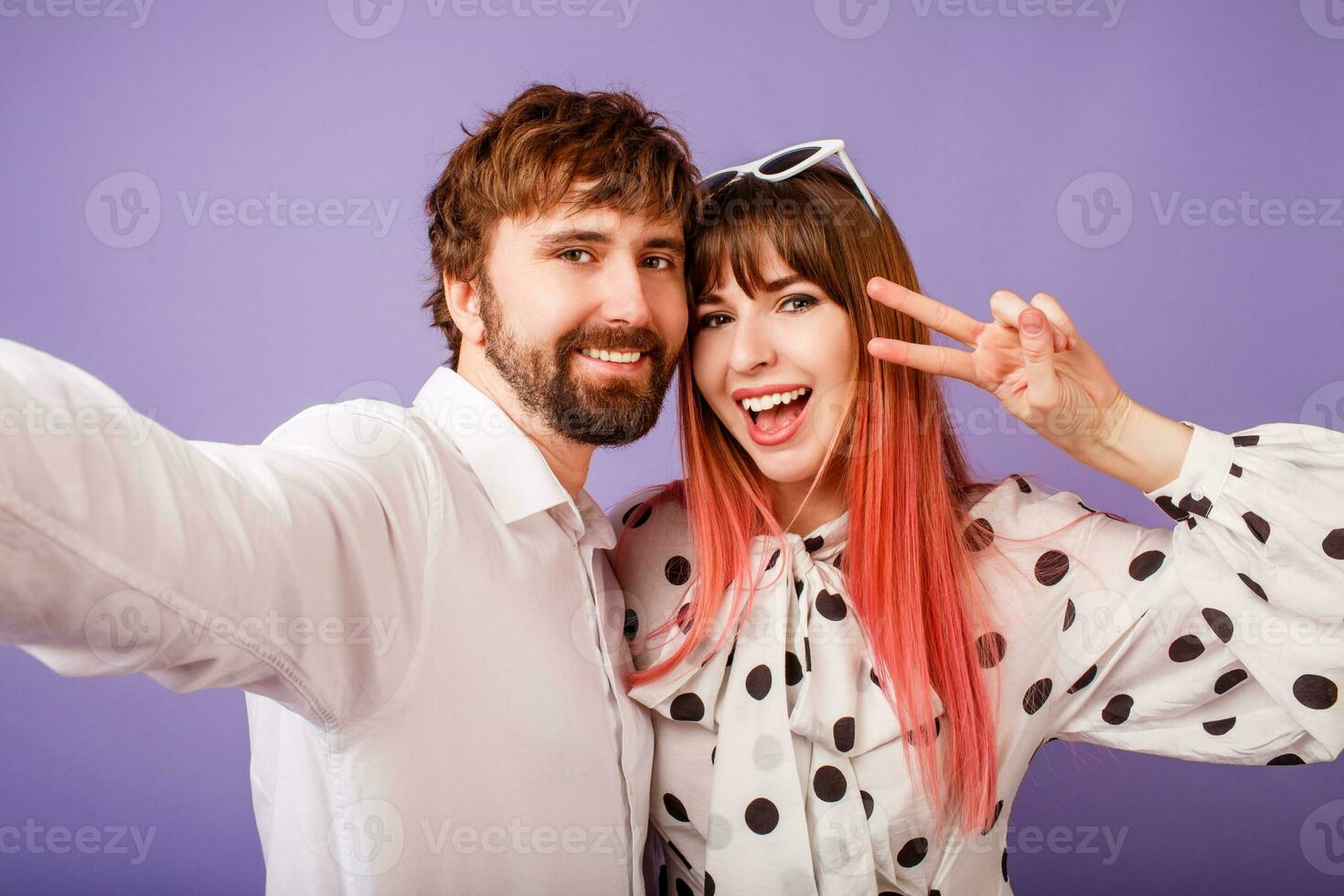 Happy couple in love making self portrait on purple background photo