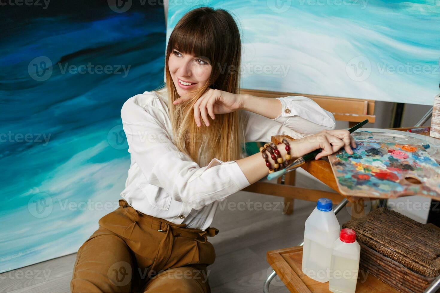 Pretty woman artist posing in her art studio. photo