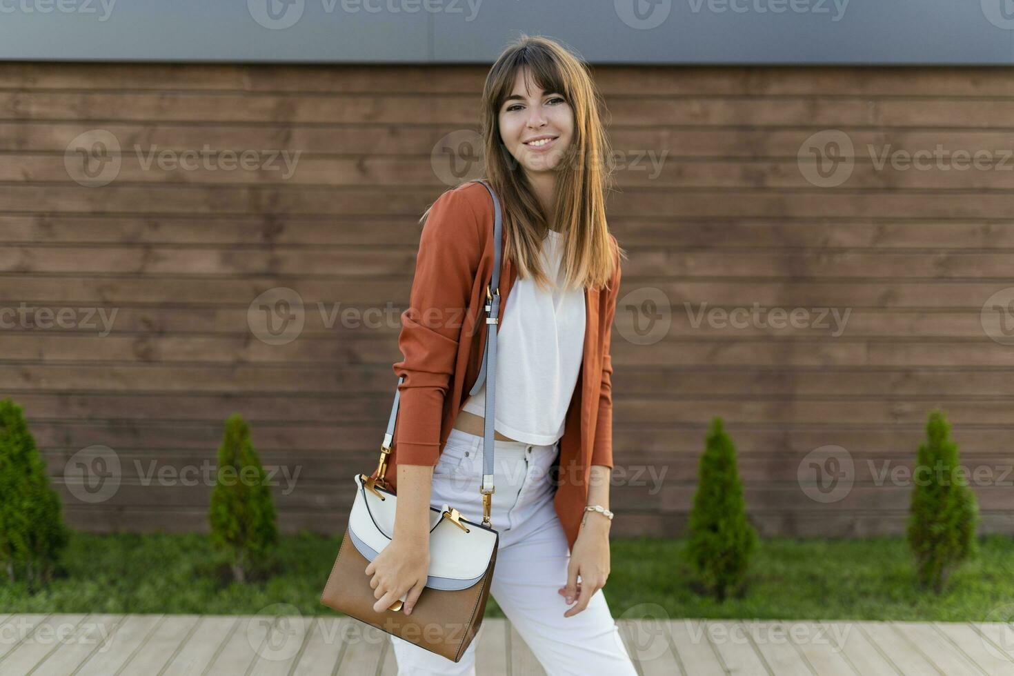 Beautiful smiling  woman in jacket posing  in the city. photo