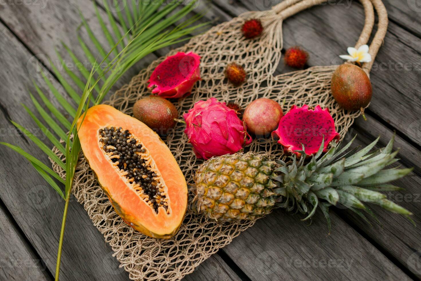 Woman hands with big plate of fresh exotic fruits photo