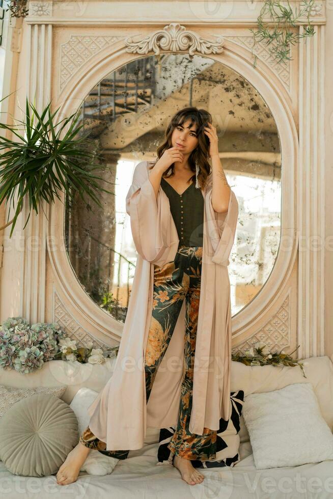 Beautiful woman in elegant wome wear posing in stylish bohemian interior. photo