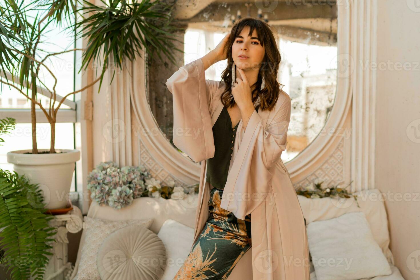 Beautiful woman in elegant wome wear posing in stylish bohemian interior. photo