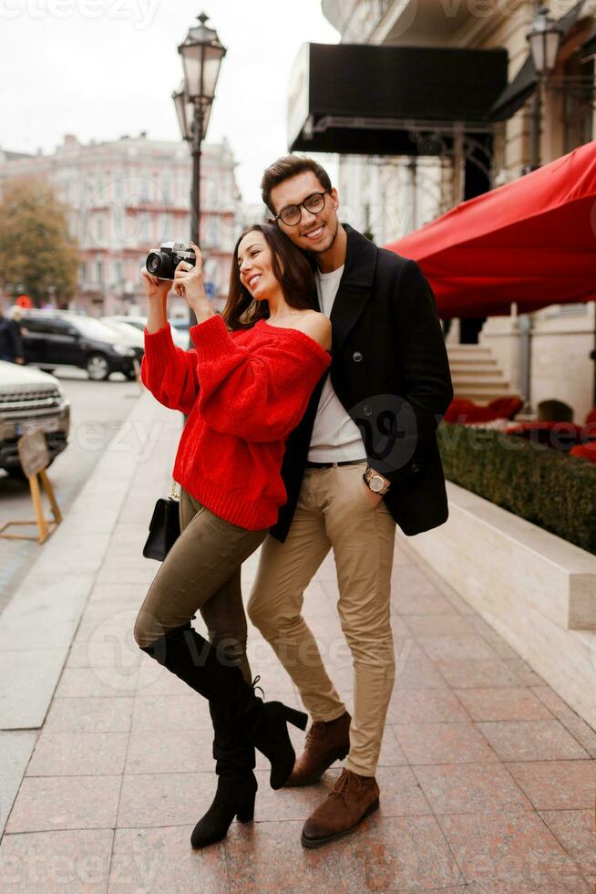 Outdoor image of fashionable elegant couple in love walking on the street during date or holidays. photo