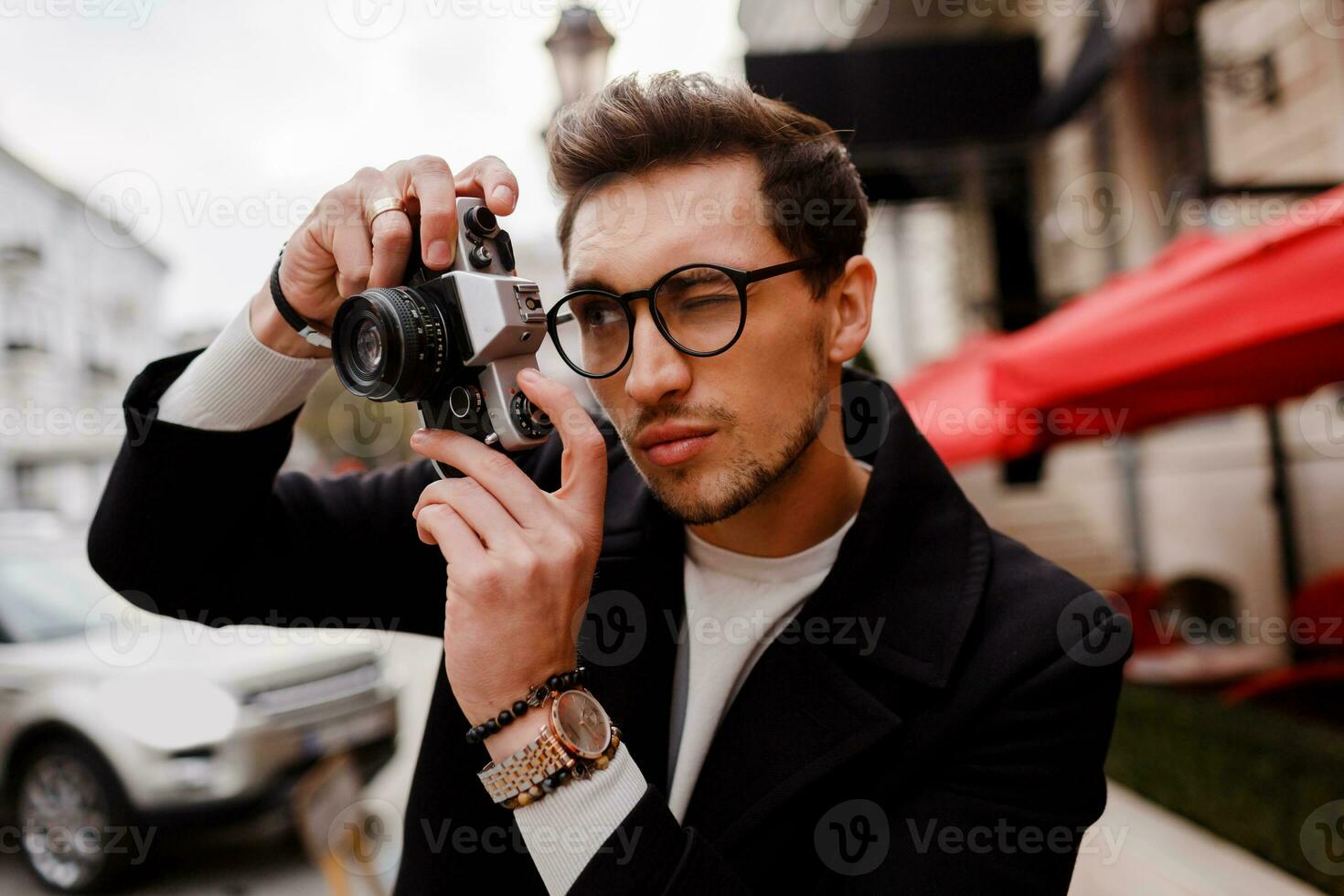 Stylish man with photocamera making photos   in  european city.
