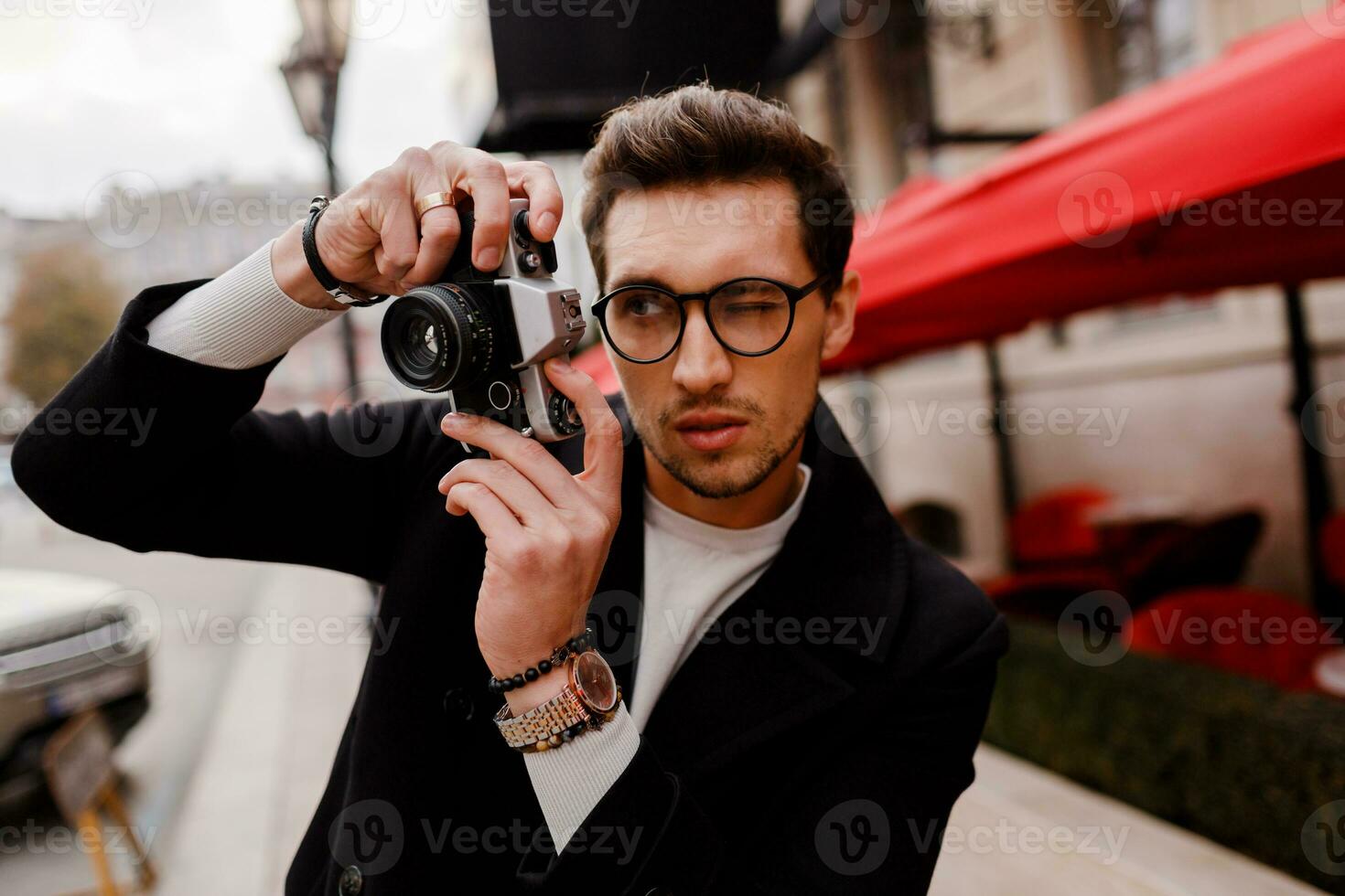 hermoso hombre con elegante peinado haciendo fotografiar en europeo ciudad. otoño estación. foto