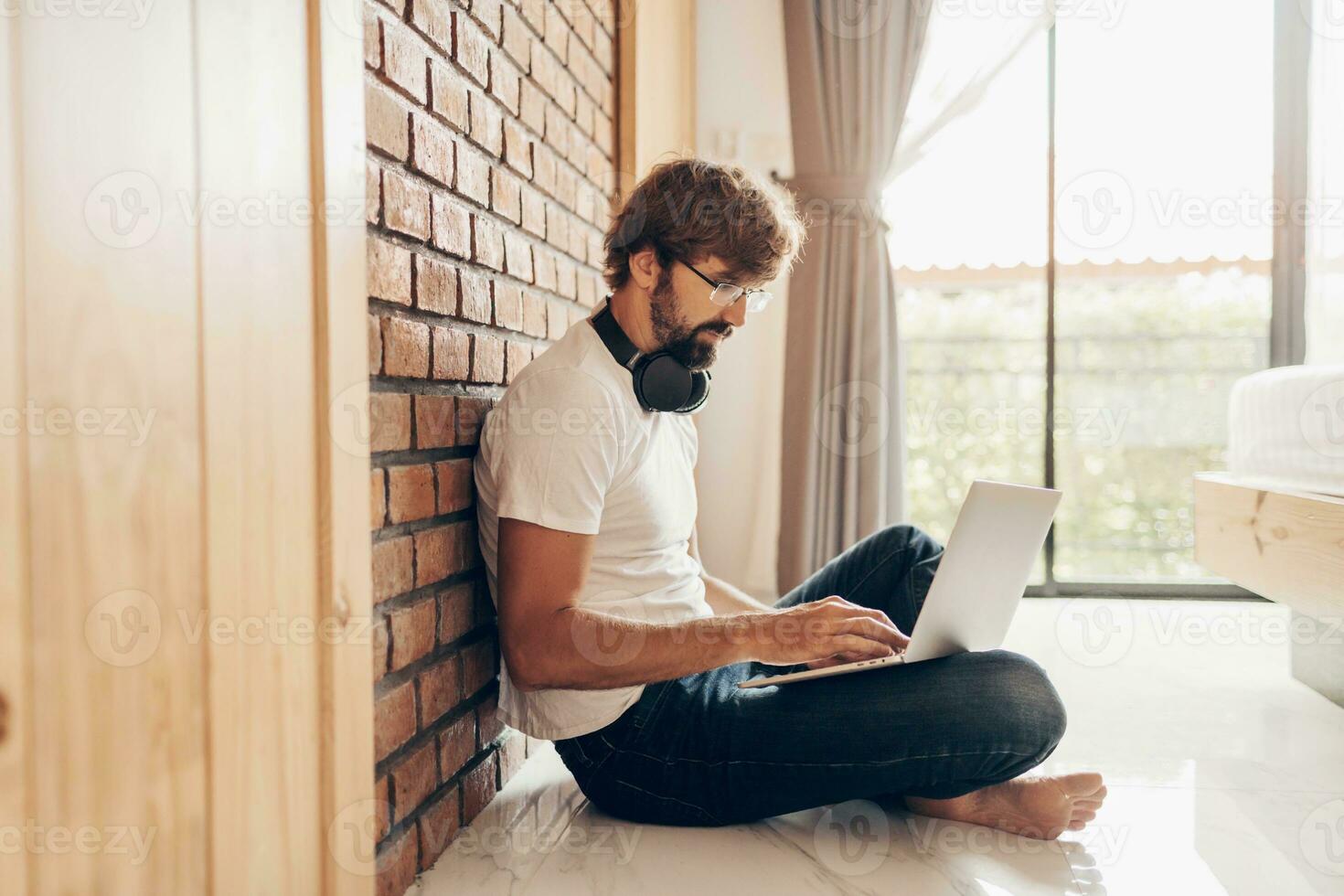 Handsome hipster man with beard using lap top at home photo