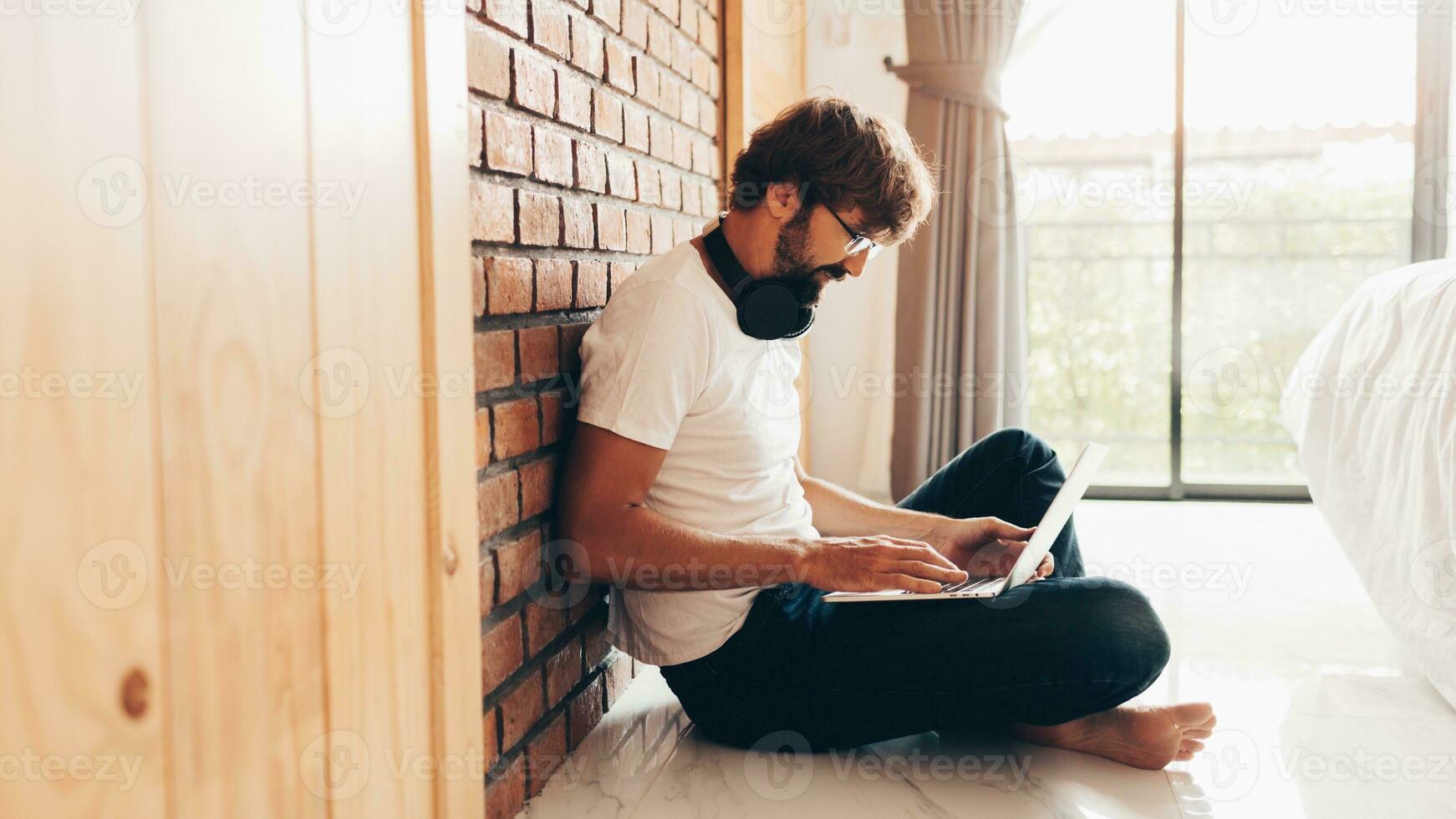 Handsome hipster man with beard using lap top at home photo