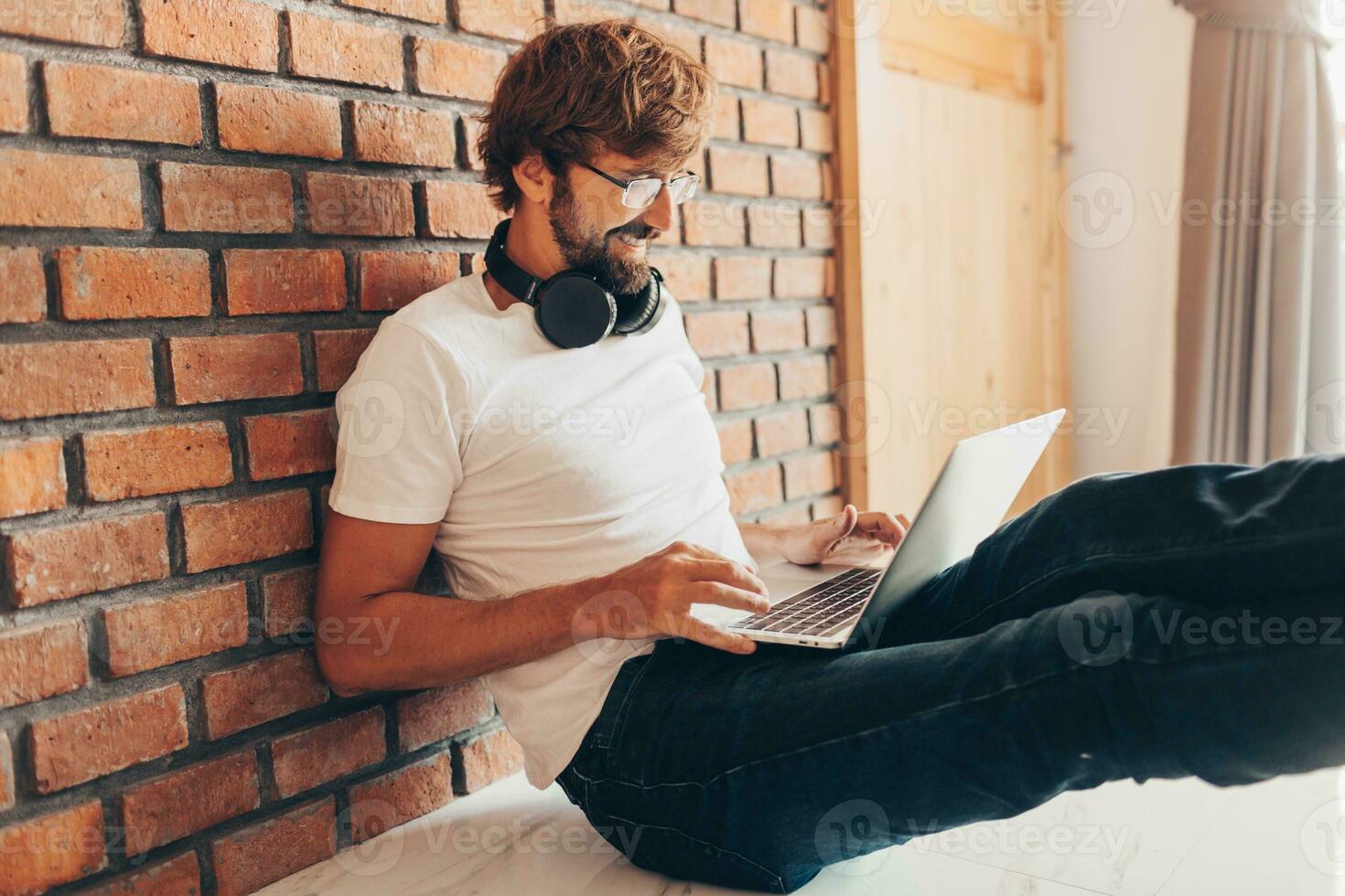 Handsome hipster man with beard using lap top at home photo