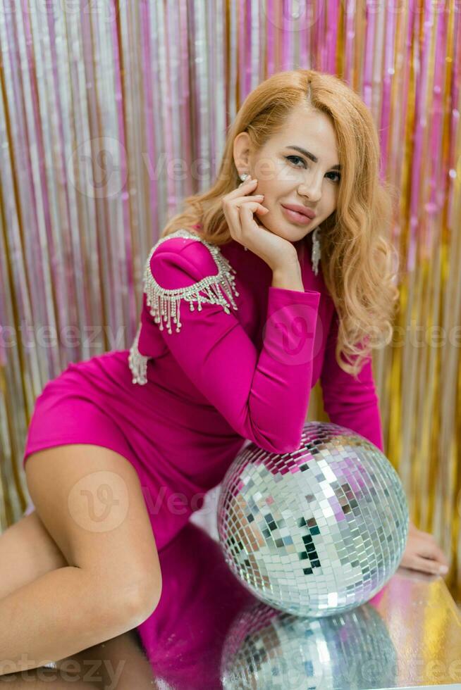 Studio photo of shiny blond woman in sexy pink dress. Perfect wavy hairs. New year  party.