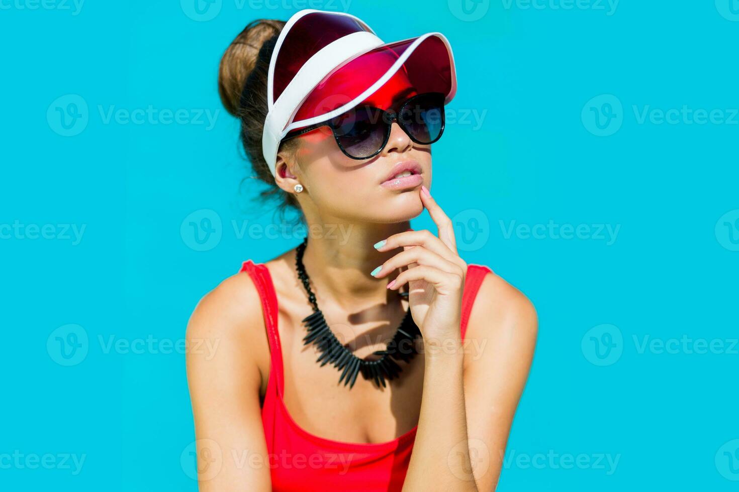 Sexy tanned    woman in red swimsuit having fun and enjoying  summer in amazing big swimming pool.  Stylish transparent cap. Beach party. photo