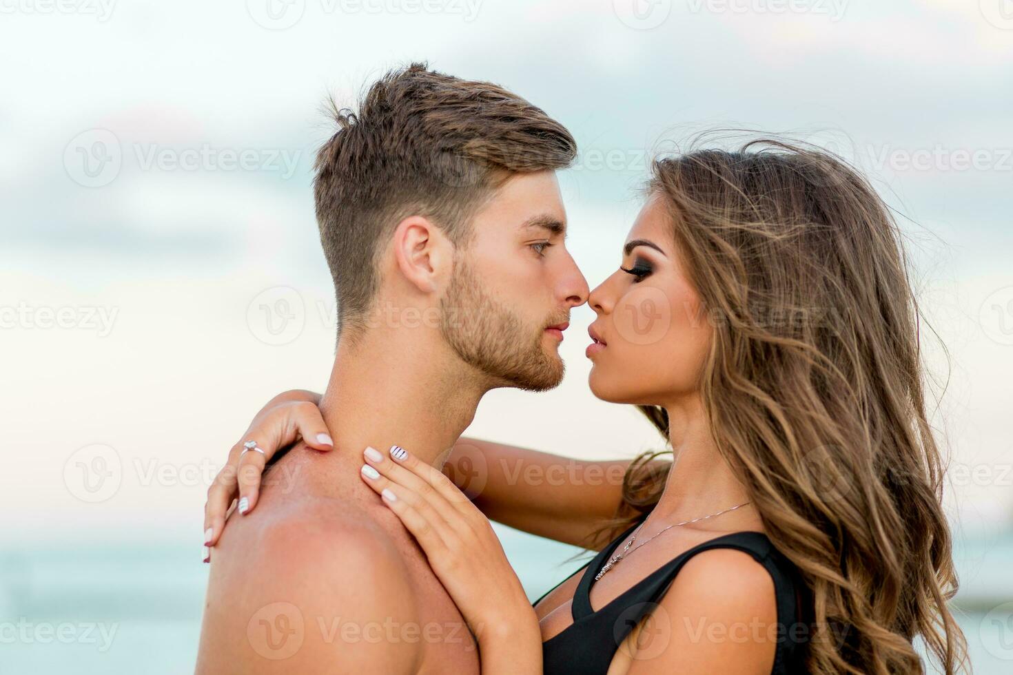 Outdoor close up fashion portrait of pretty sexy couple in love  hugs on  amazing tropical  beach, wearing stylish swimwear. photo