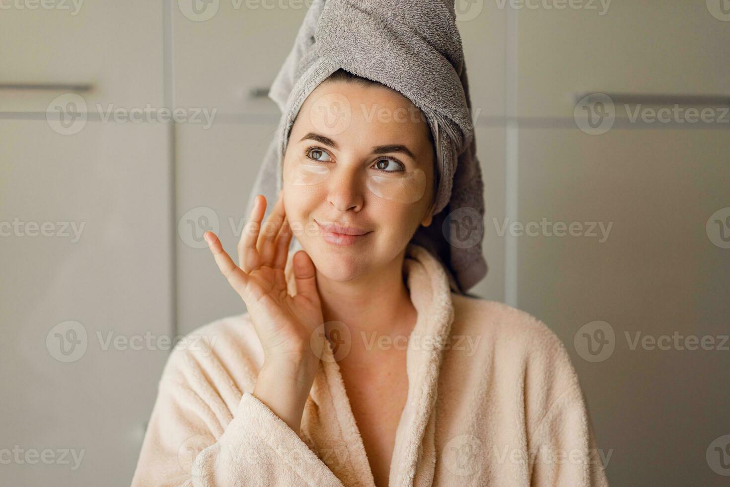 Beautiful young woman with natural make up shows gel, cream or mask sample on her face. SPA, wellness, bodycare and skincare. Close up, selective focus. photo
