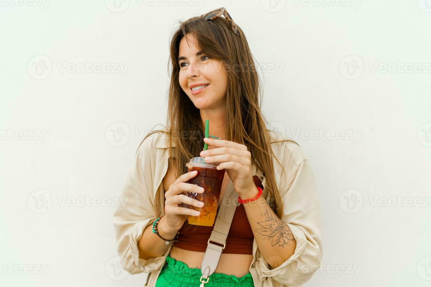 Summer portrait of stylish brunette woman  enjoing sweety lemonade and posing on white background. photo
