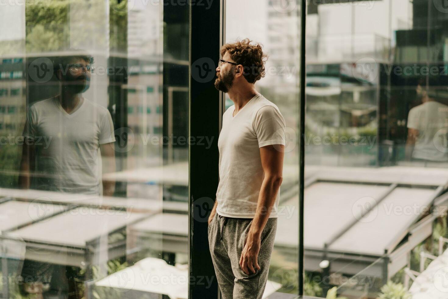 Handsome confident stylish  male. Modern man dressed in white shirt. Fashion male posing in the street background near skyscrapers. photo