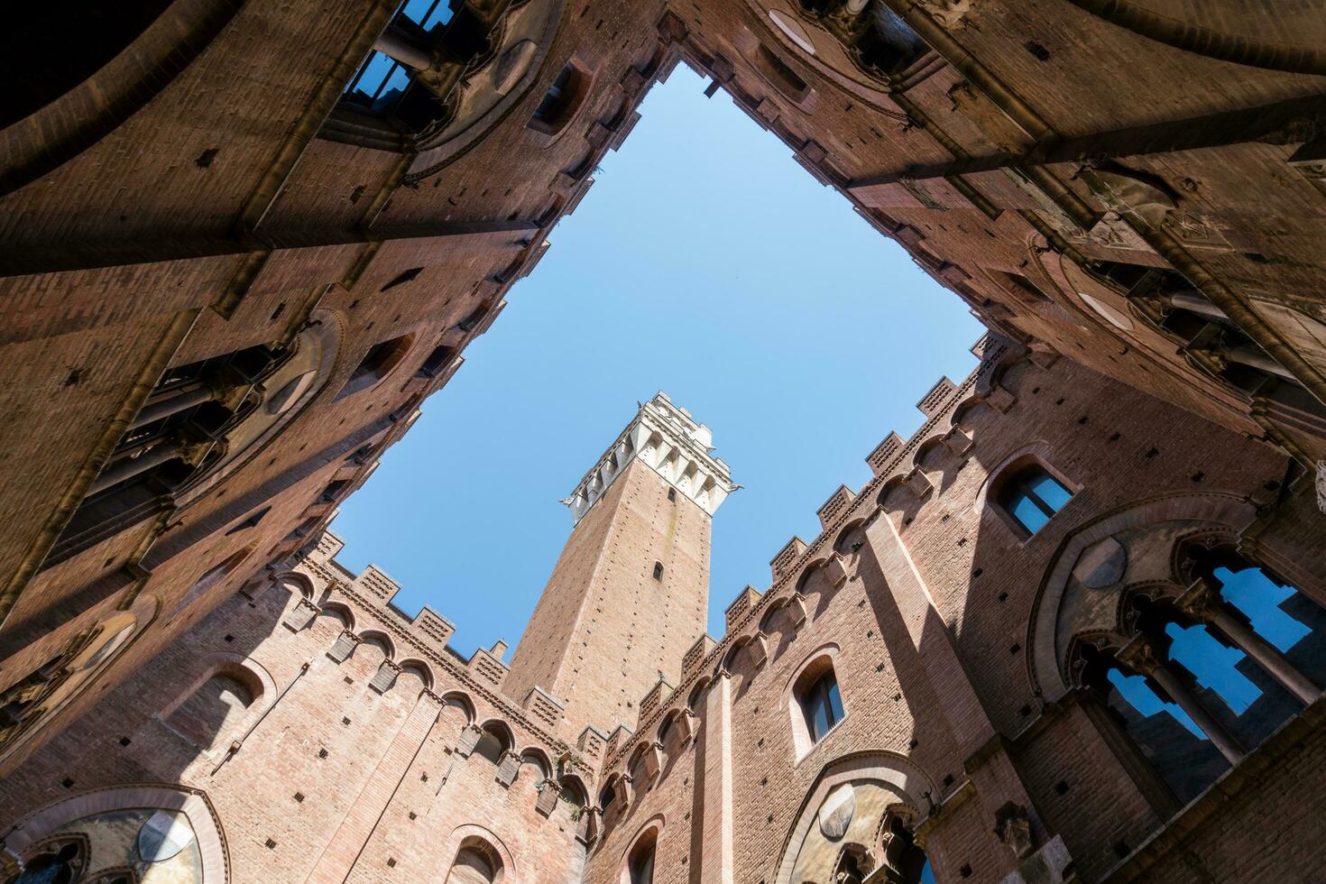 Siena ,Italy-august 10, 2020-view of the Mangia tower in piazza del campo from the internal courtyard of the civic museum during a sunny day photo