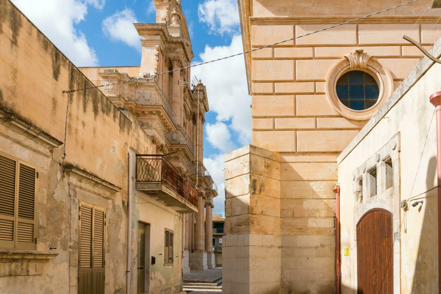 Ispica, Italy-May 8, 2022-walking through the narrow streets of Ispica in Sicily during a sunny day photo