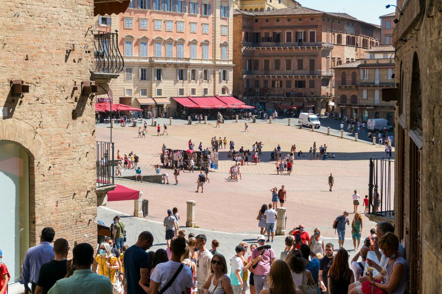Siena ,Italy-august 10, 2020-Tourists and souvenir shops in Siena near the Campo square during a sunny day photo