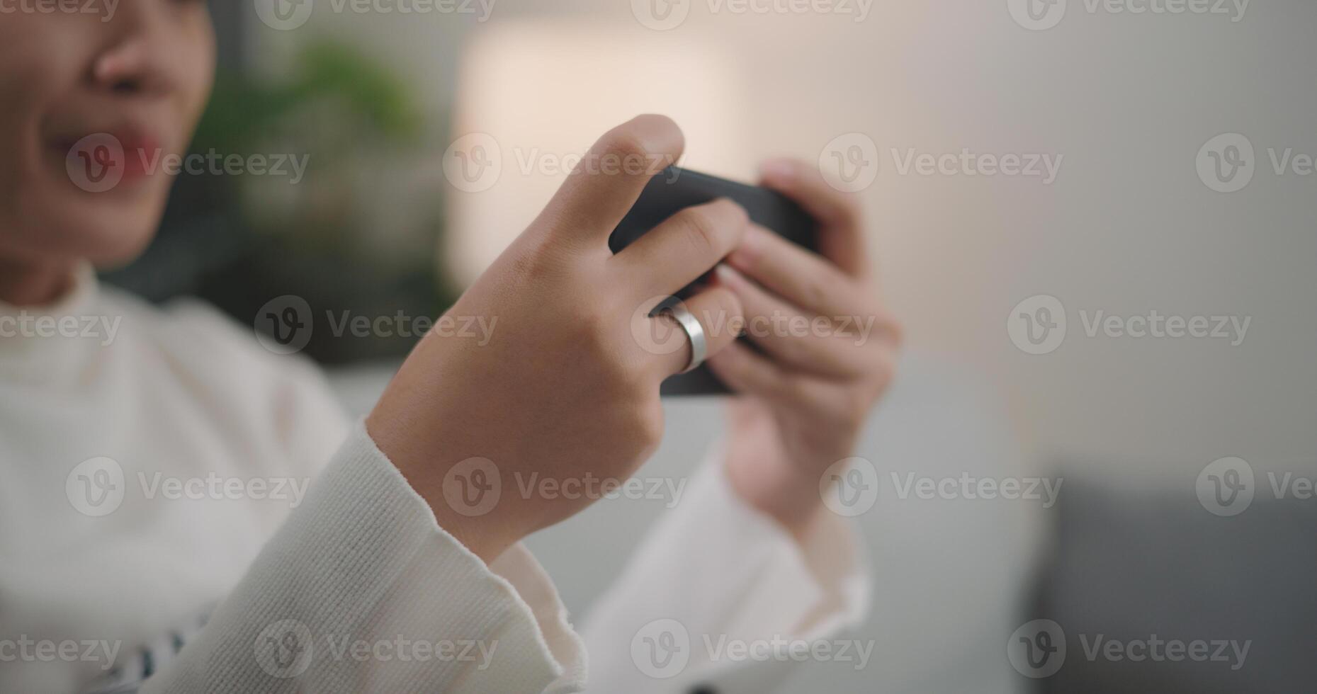 Asian woman playing a game on smartphone photo