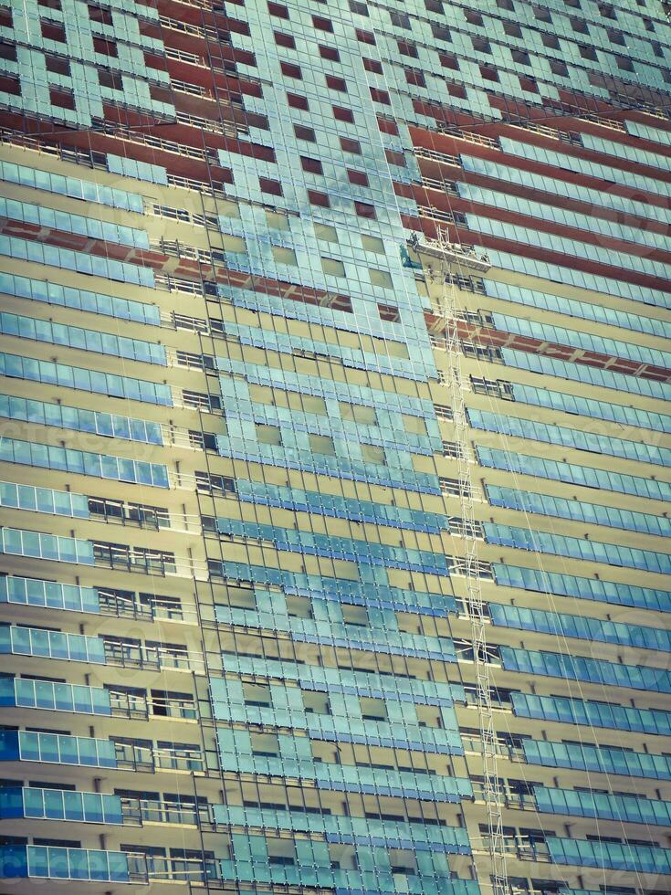 Unfinished modern building with blue mirrored exterior. photo