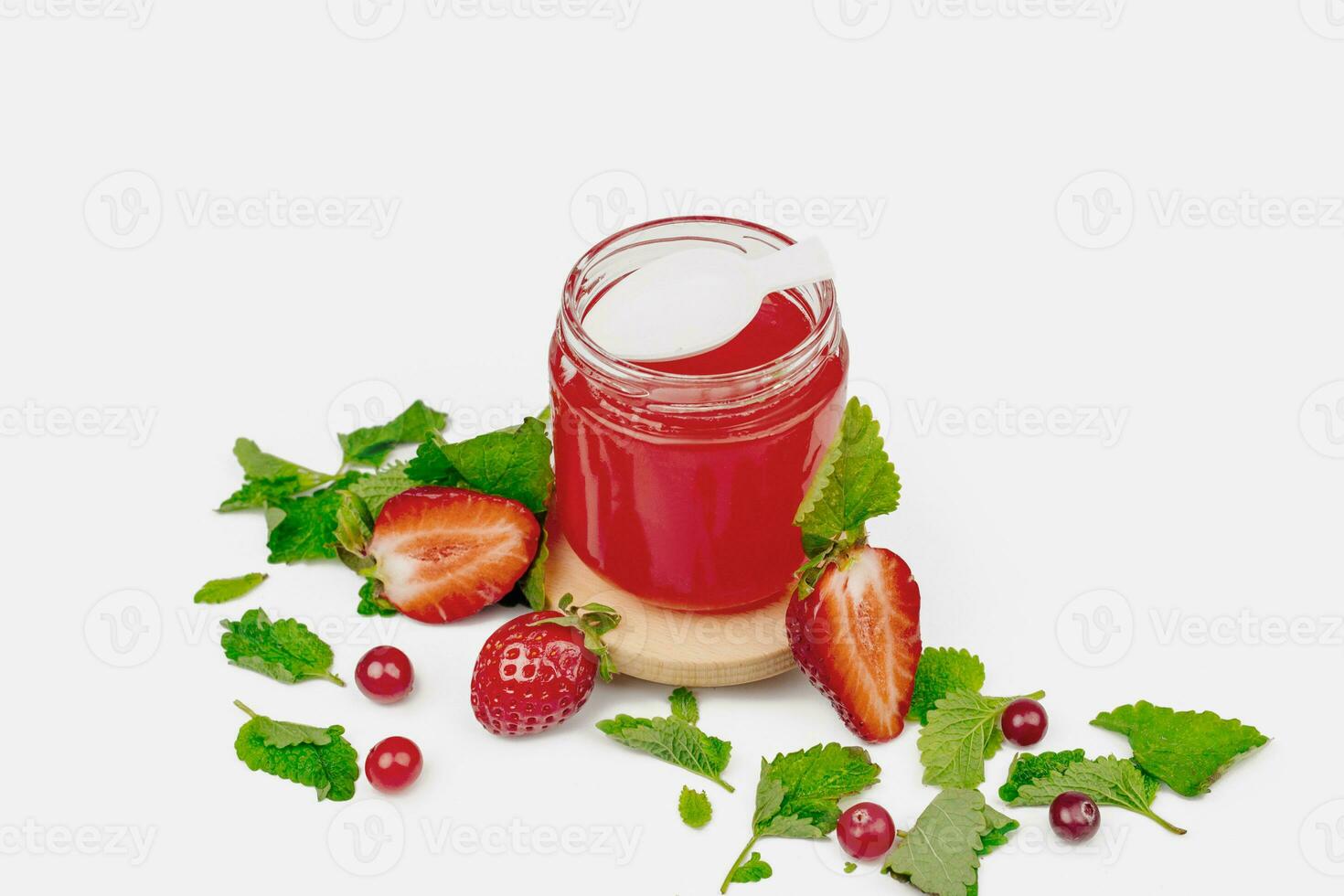 Fruit jelly in a jar with fresh strawberry and mint. Mockup dessert. Healthy food. Close-up Strawberry jelly on white background. Free space for text photo