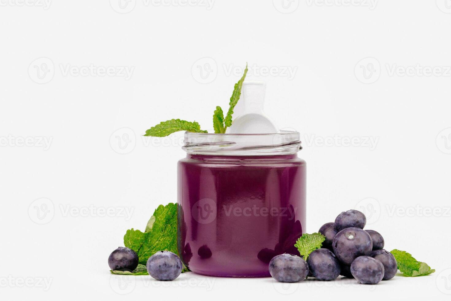 Fruit jelly in a jar with fresh blueberries and mint. Mockup dessert. Healthy food. Close-up Blueberry jelly on white background. Free space for text photo
