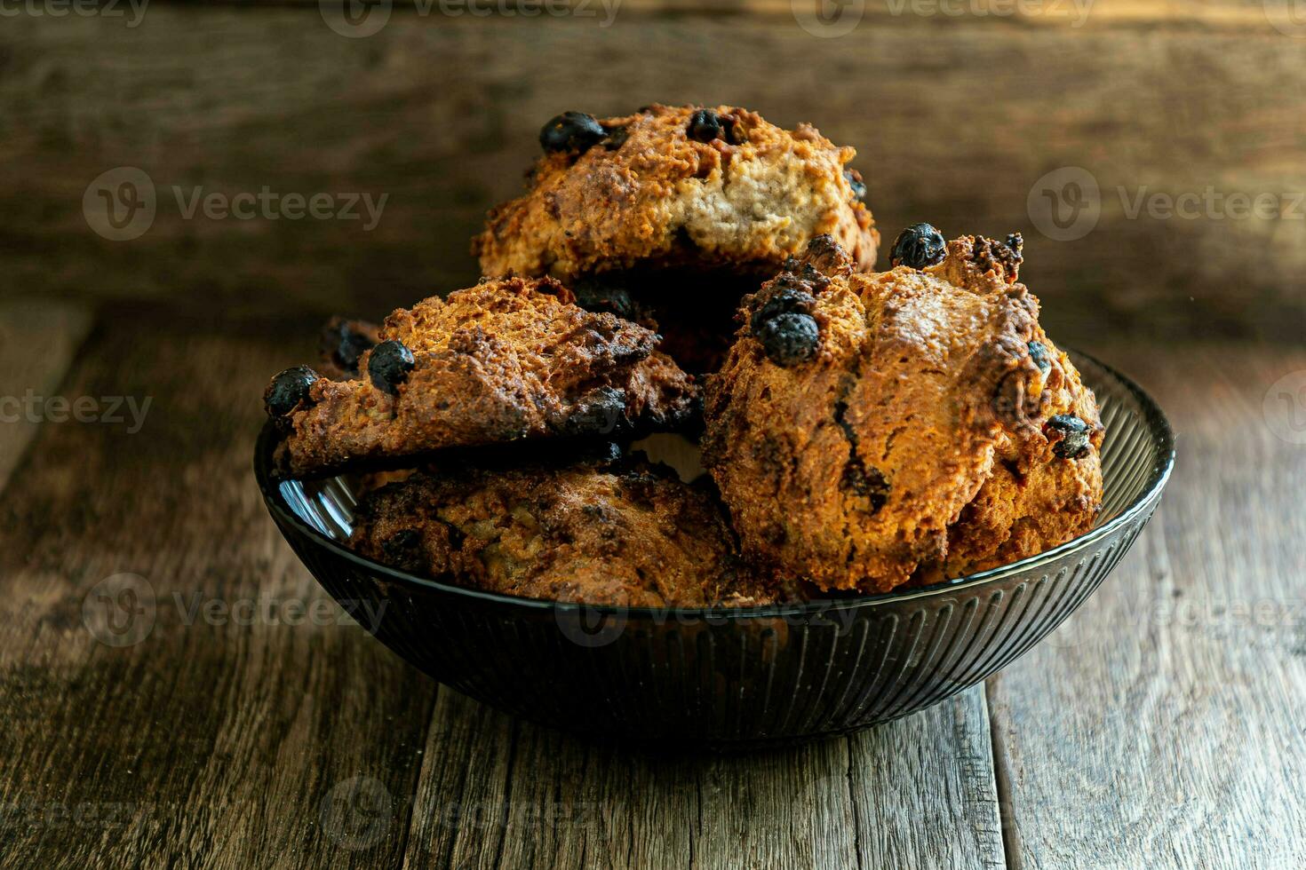 Homemade oatmeal cookies in a glass brown bowl on a kitchen napkin on a wooden table. photo