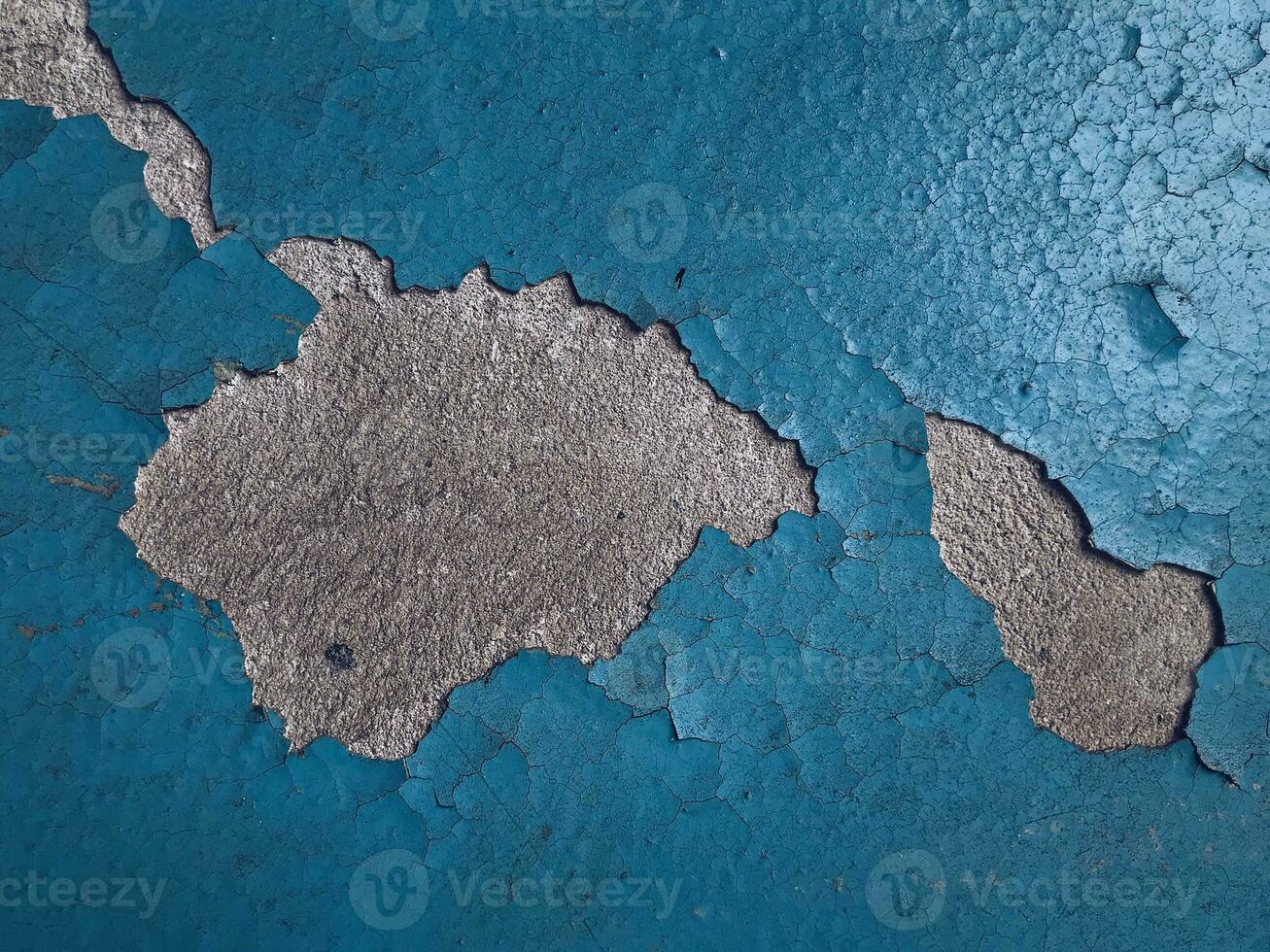 Blue paint on old concrete wall with cracks as background texture photo