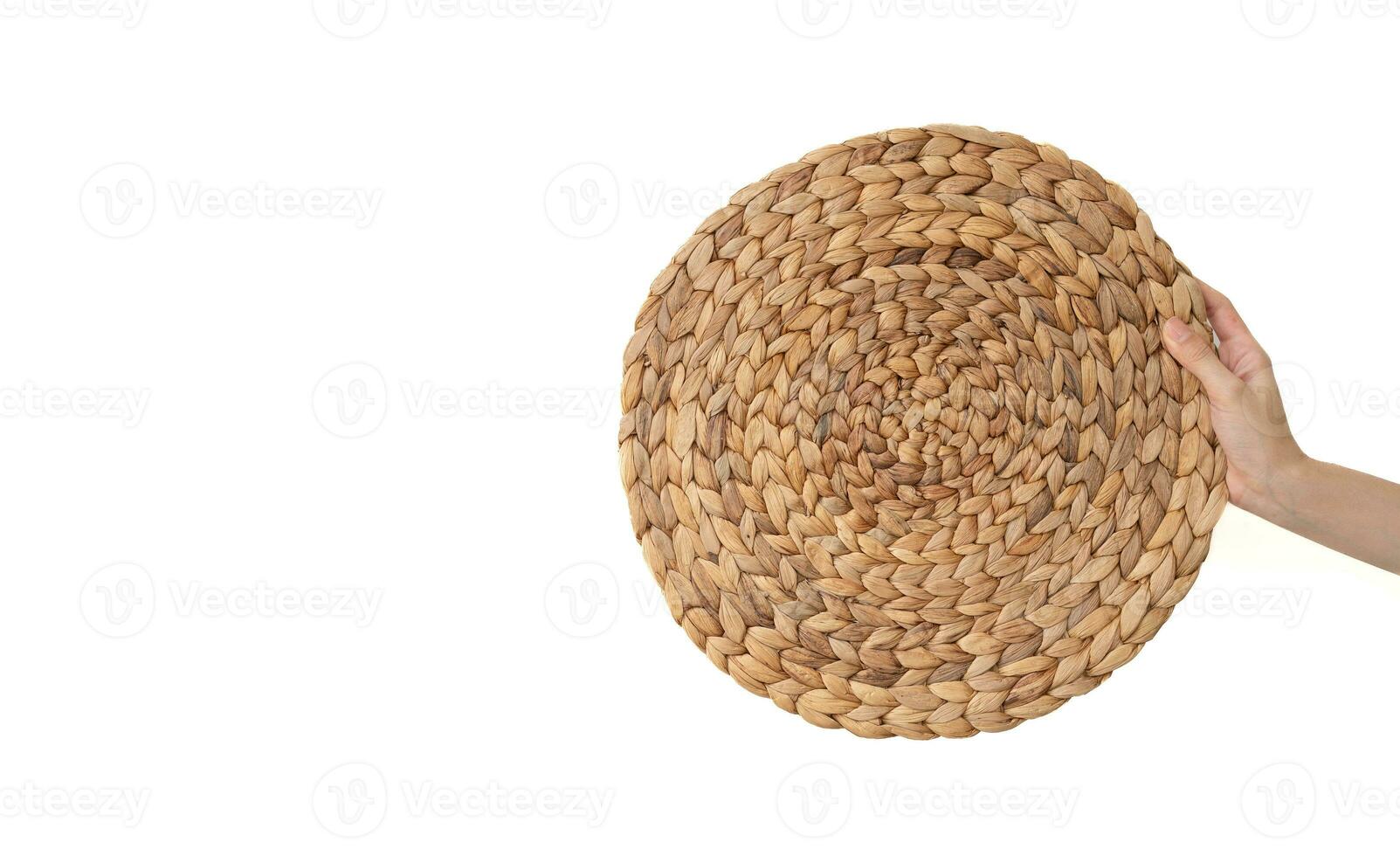Hand holding Straw table mats on the white isolate background. photo