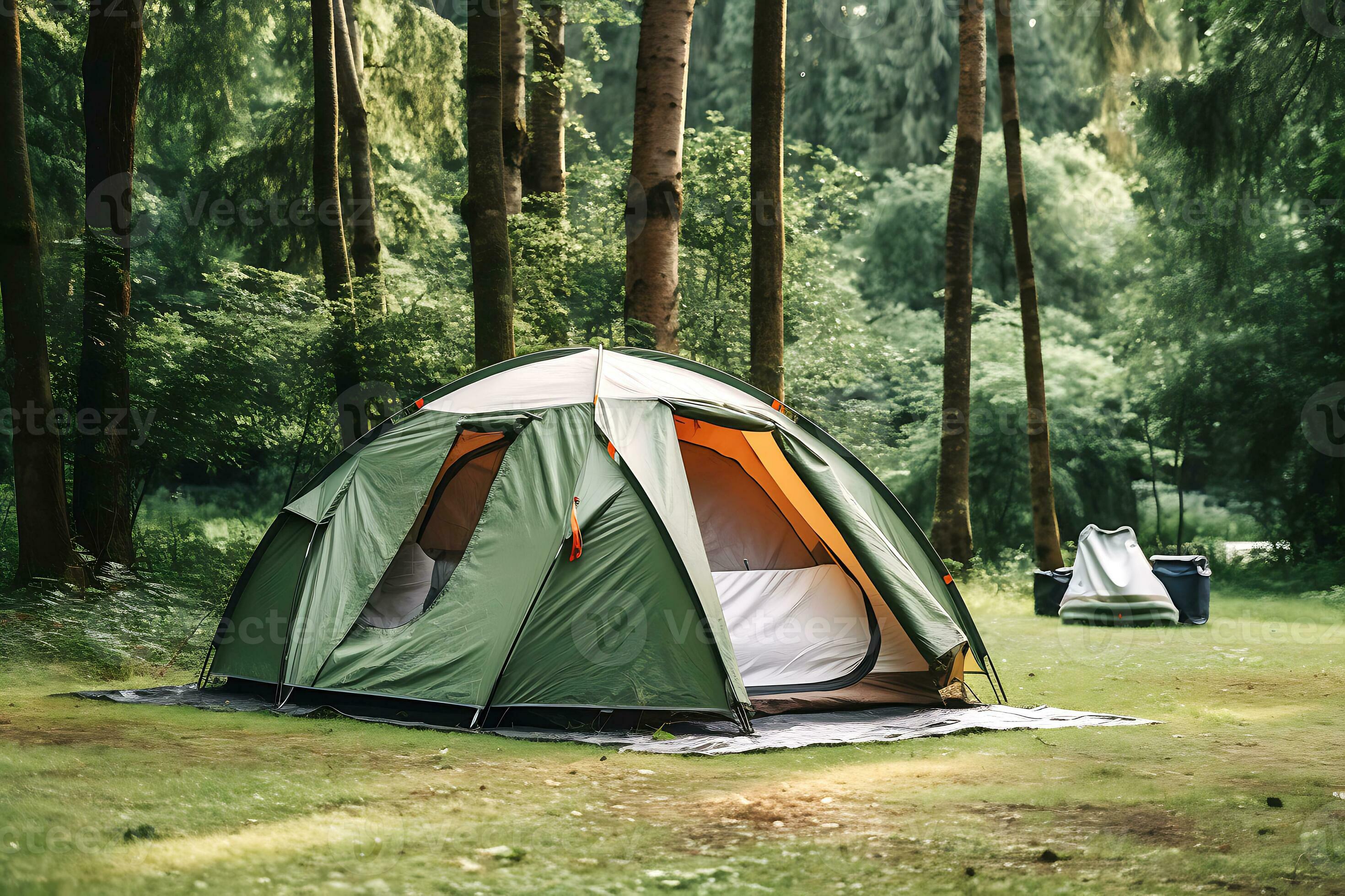 A tourist tent stands on a lawn in the middle of a forest in the