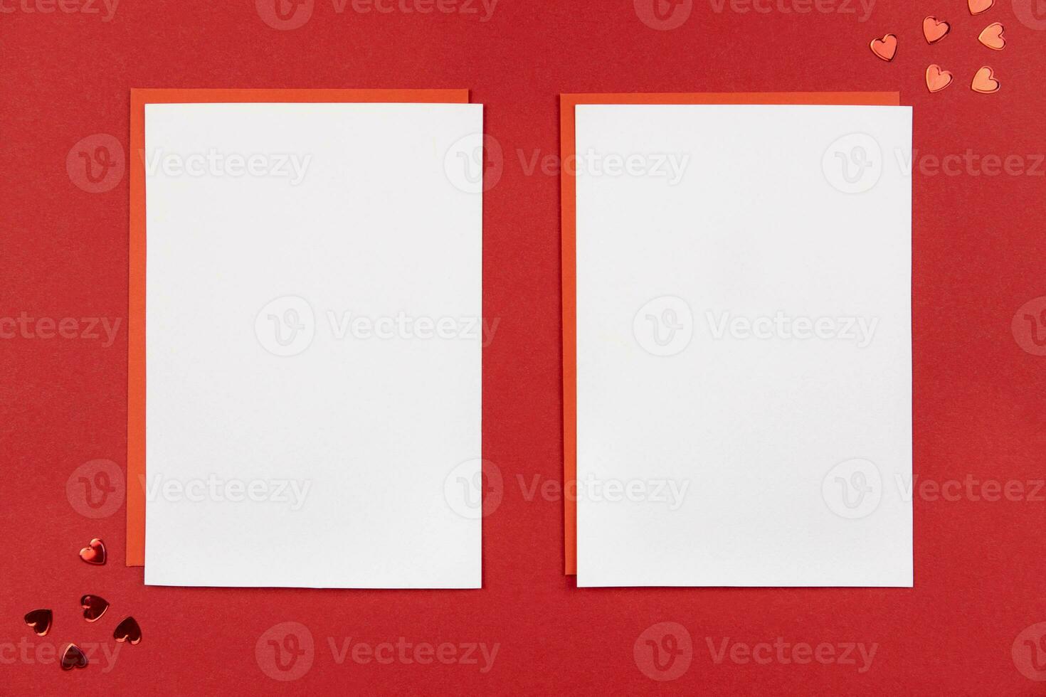 Blank greeting cards mockups and envelope on red background with hearts confetti. Valentines, mothers, womens day or wedding flat lay composition. Top view. Copy space. photo