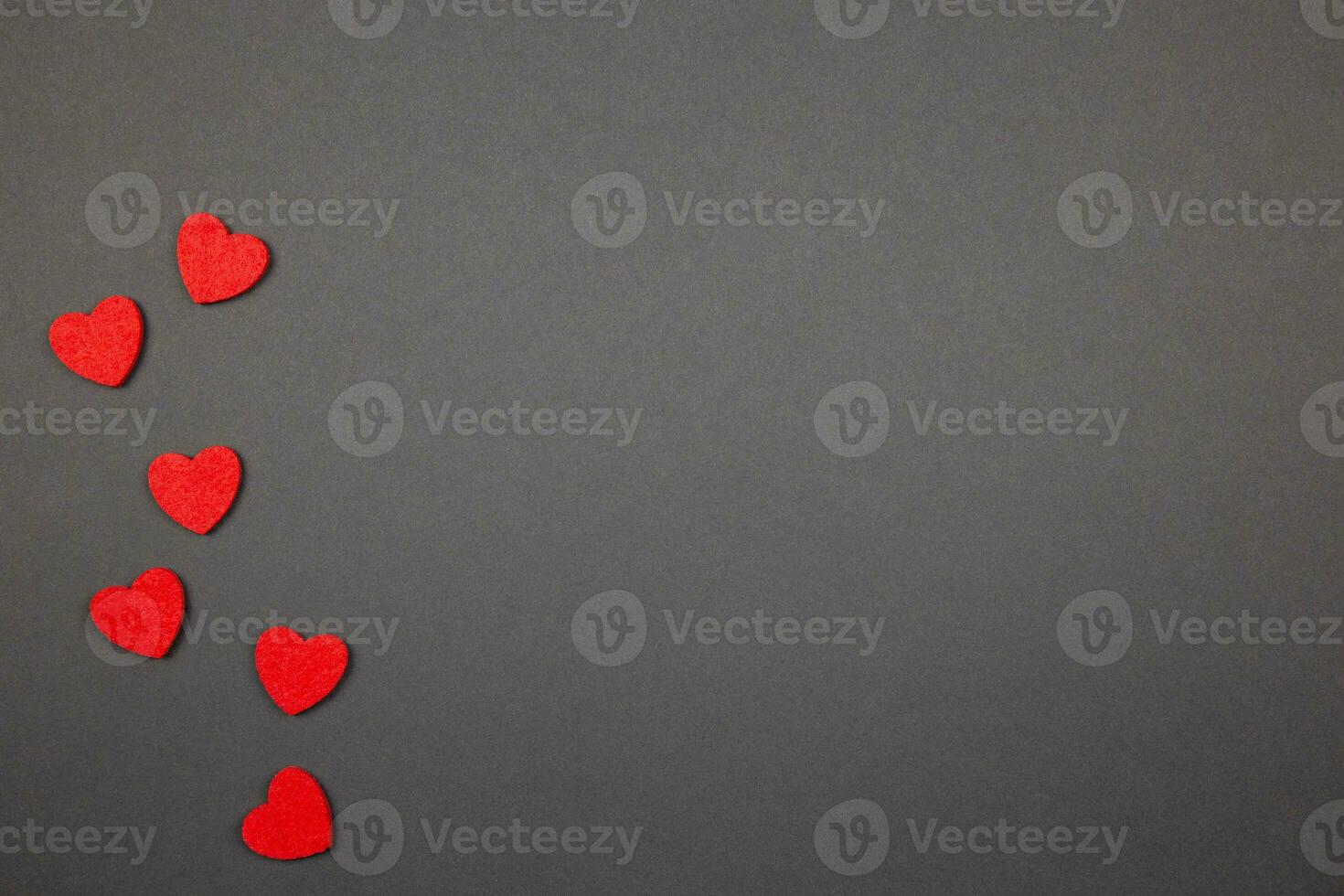 Red hearts confetti on dark background. Valentines, mothers, womens day, wedding or birthday flat lay concept. Top view. Copy space. photo