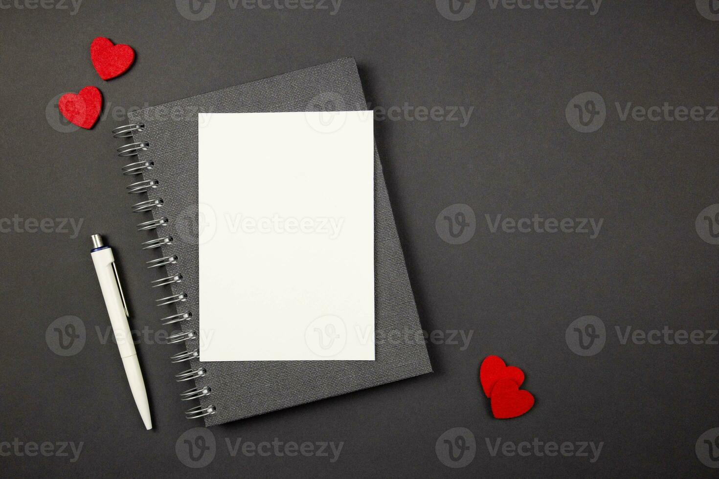 Greeting card mockup with red hearts on dark background. Valentines, mothers, womens day, anniversary and birthday greeting flat lay. Top view. Copy space. photo