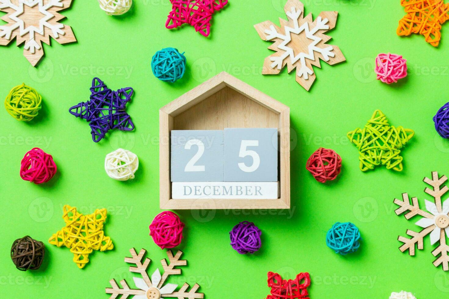 Top view of wooden calendar. The twenty fifth of December. New Year decorations on green background. Festive stars and balls. Merry Christmas concept photo