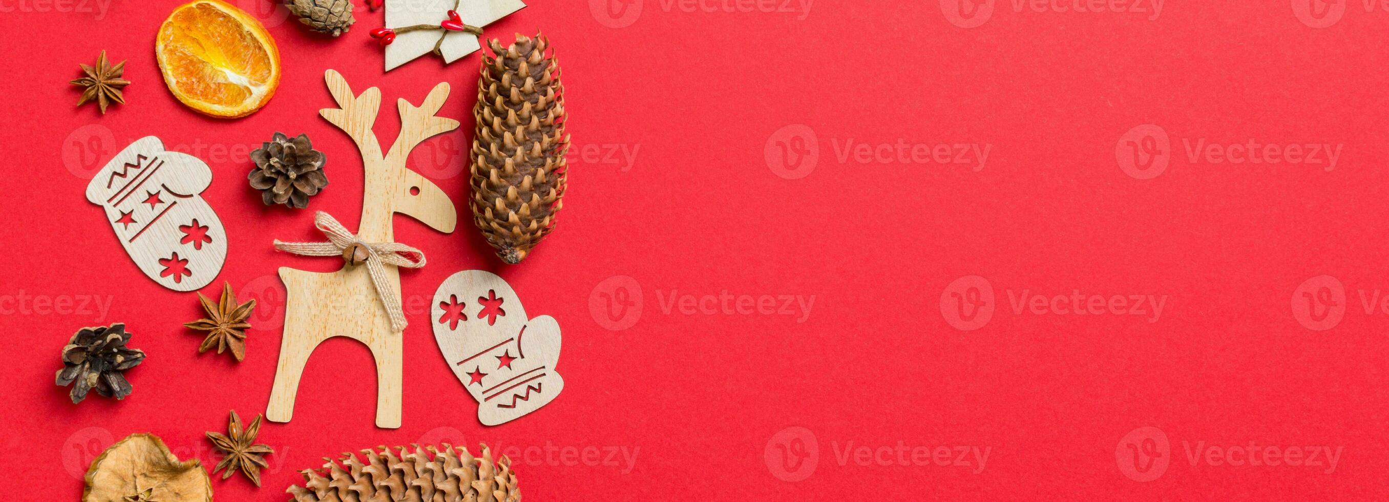Top view Banner of red background decorated with festive toys and Christmas symbols reindeers and New Year trees. Holiday concept with copy space photo