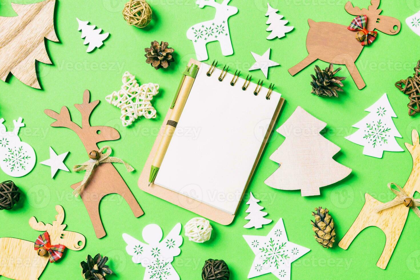 Christmas green background with holiday toys and decorations. Top view of notebook. Happy New Year concept photo