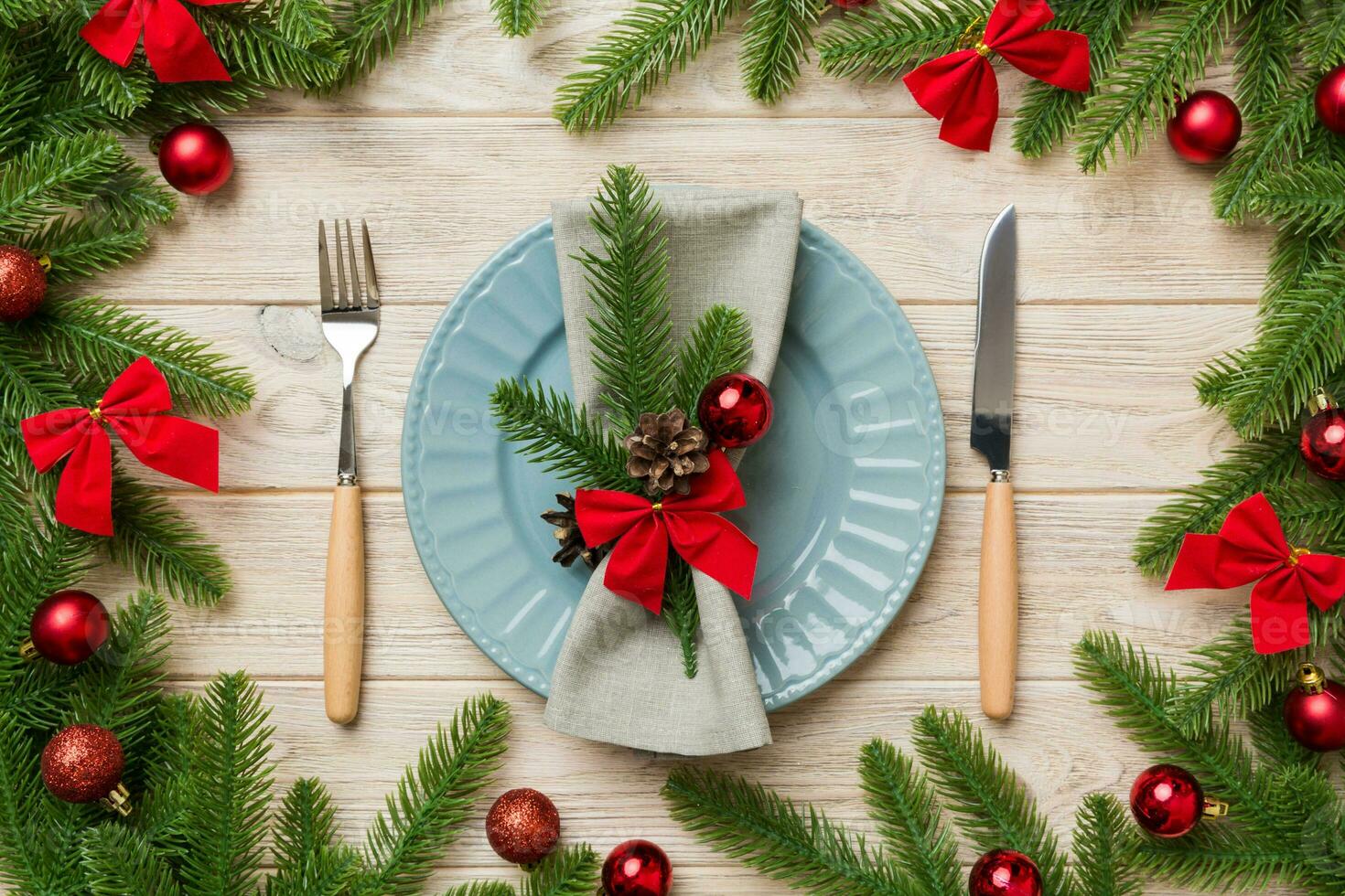 Christmas table place setting with christmas decor and plates, kine, fork and spoon. Christmas holiday background. Top view photo