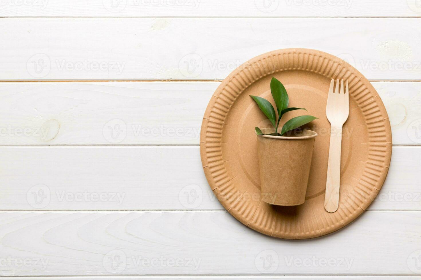 set of empty reusable disposable eco-friendly plates, cups, utensils on light white colored table background. top view. Biodegradable craft dishes. Recycling concept. Close-up photo