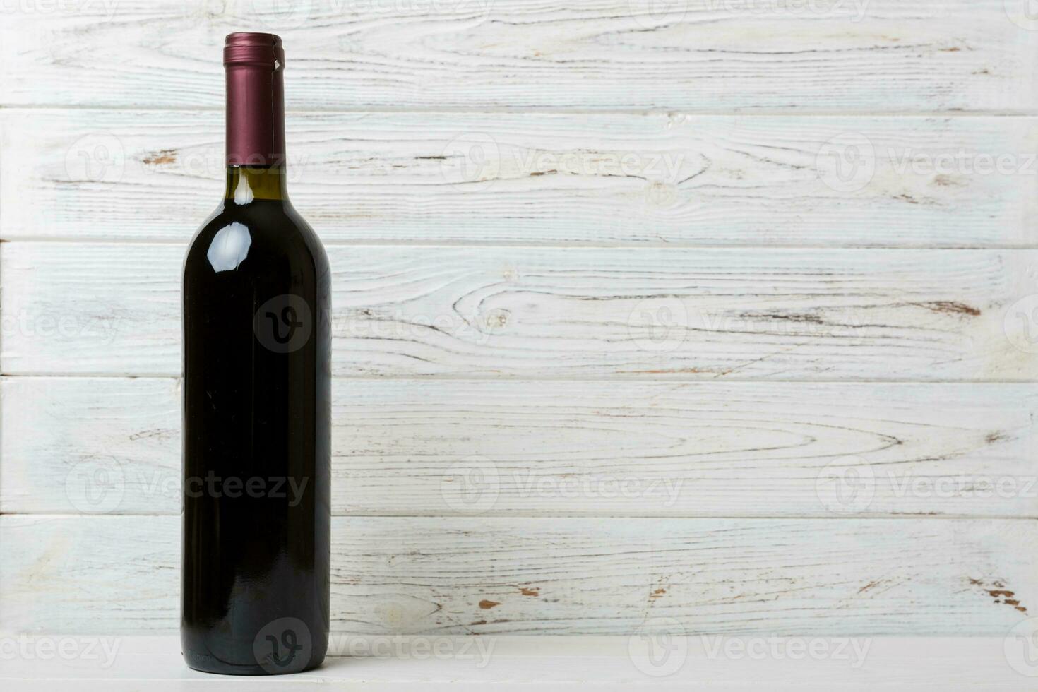 One Bottle of red wine on colored table. Flat lay, top view wth copy space photo