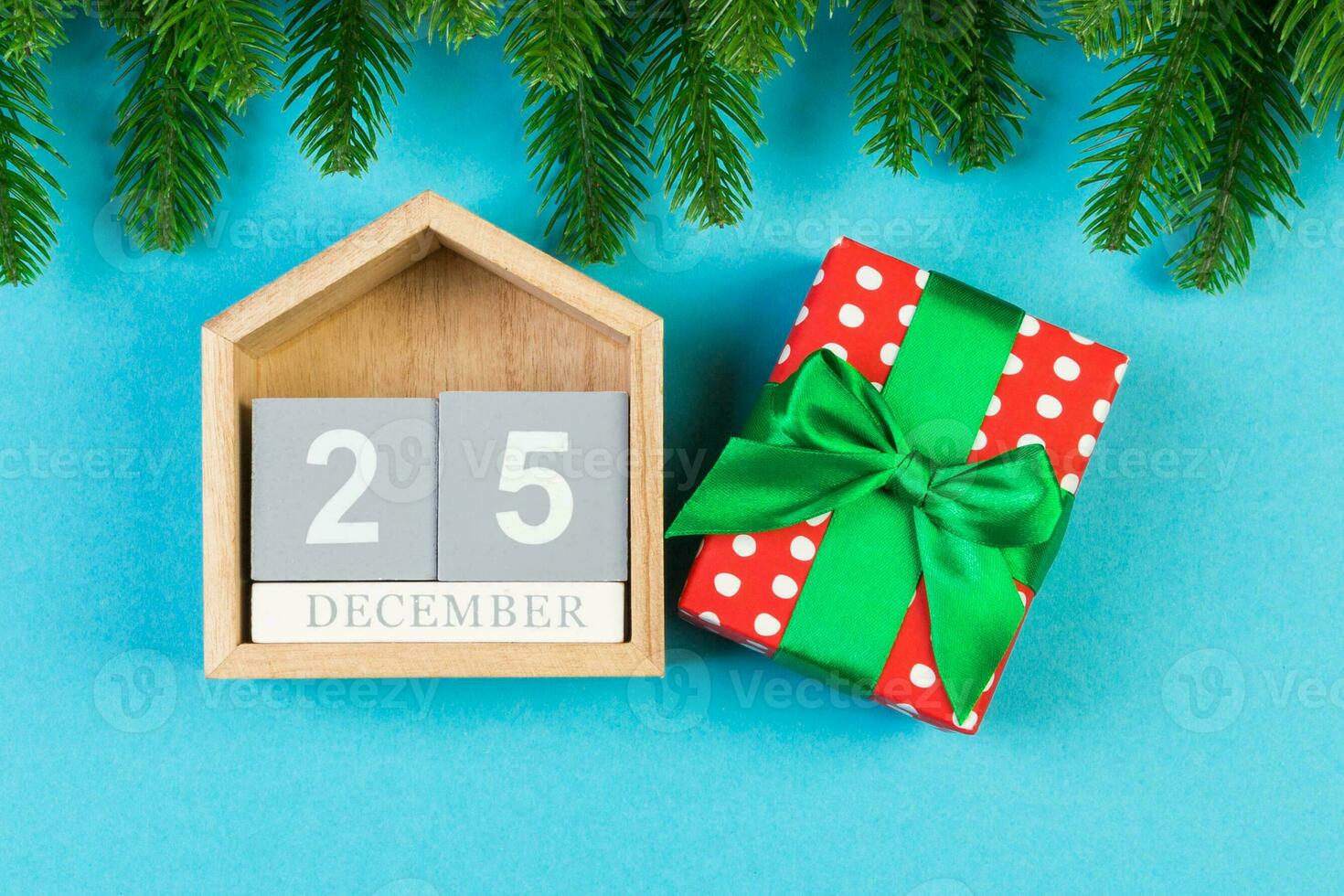 Top view of wooden calendar, gift box and fir tree on colorful background. The twenty fifth of December. Christmas time with copy space photo