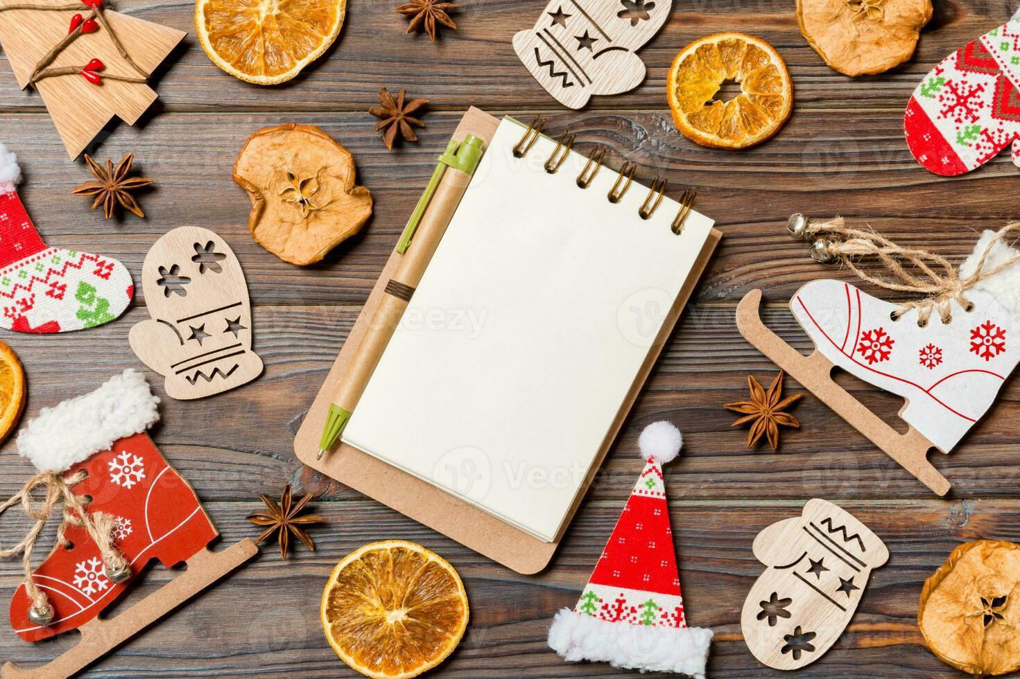 Top view of notebook on wooden background made of Christmas decorations. New Year concept photo