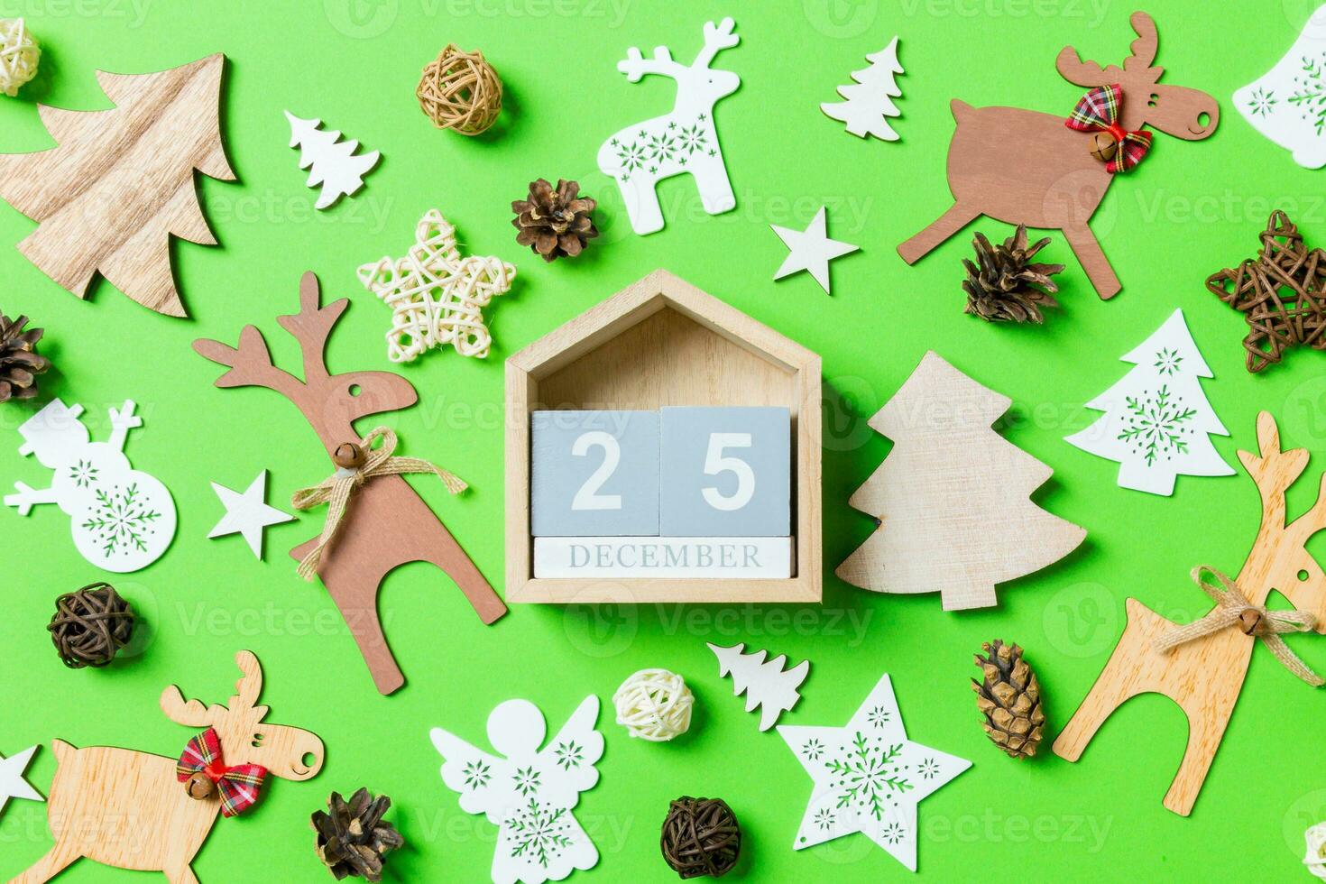 Christmas green background with holiday toys and decorations. Top view of wooden calendar. The twenty fifth of December. Merry Christmas concept photo