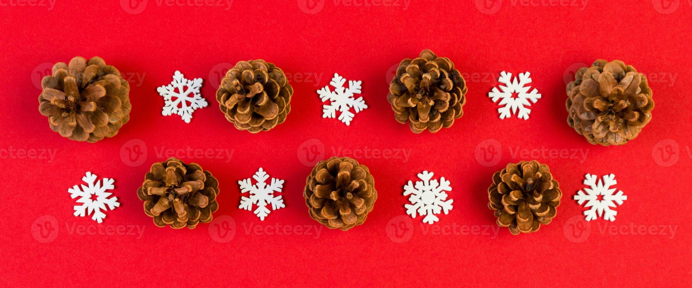 Top view of New Year ornament made of white snowflakes Banner and pine cones on colorful background. Winter holiday concept with empty space for your design photo