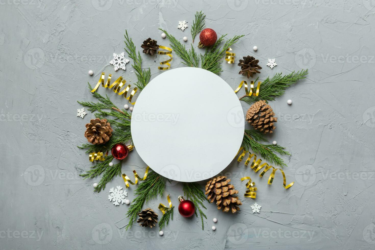Flat lay Christmas composition. Round Paper blank, pine tree branches, christmas decorations on Colored background. Top view, copy space for text photo