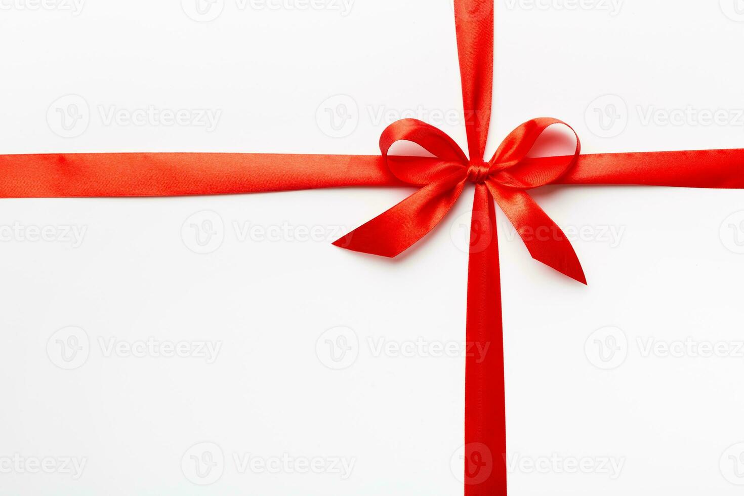 Top view of Red ribbon rolled and red bow isolated on colored background. Flat lay with copy space photo