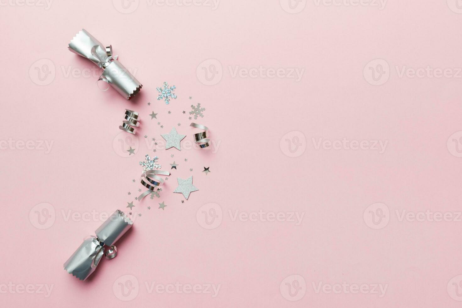 Christmas crackers with shiny confetti on color background, top view, copy space photo