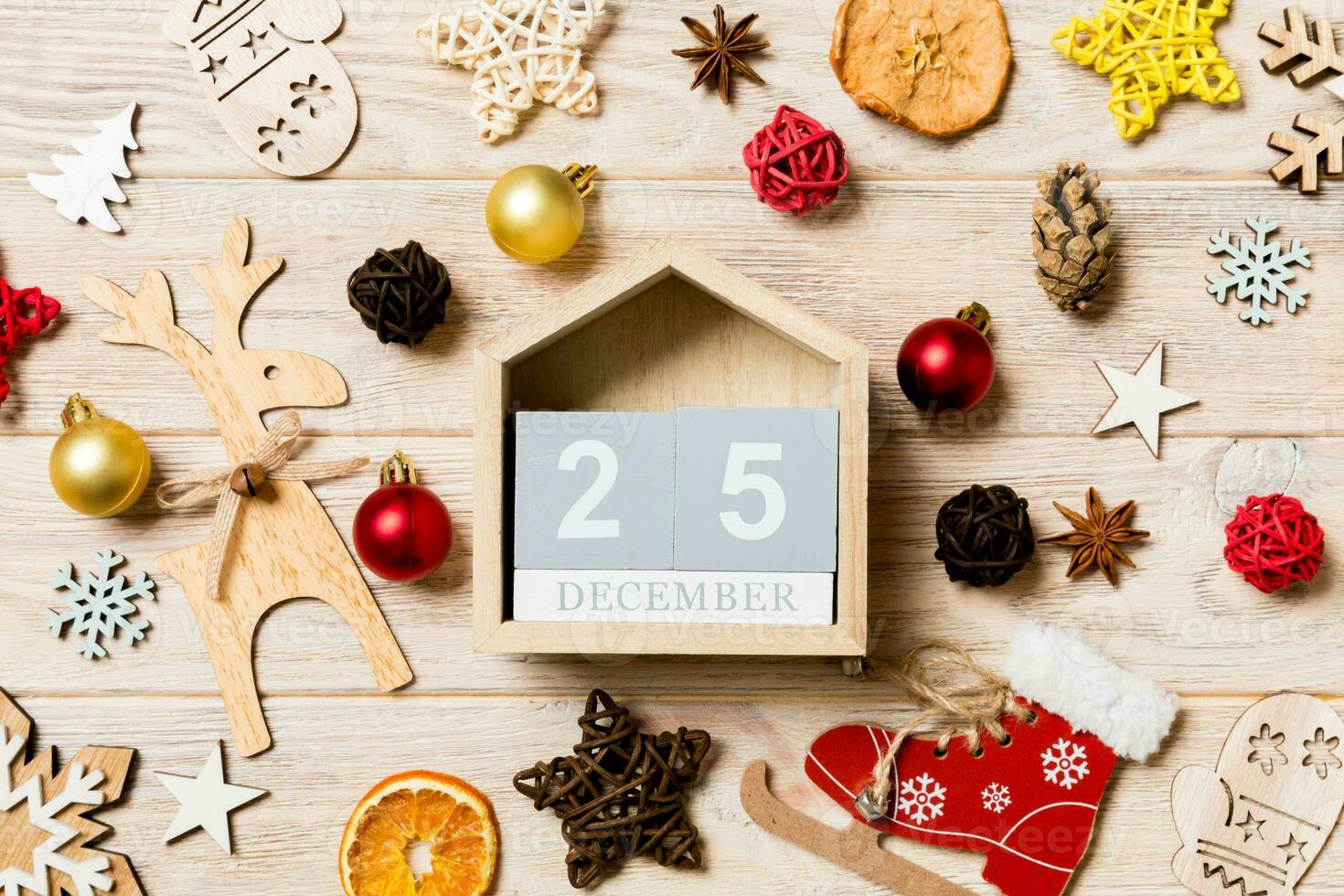 Top view of calendar on Christmas wooden background. The twenty fifth of December. New Year toys and decorations. Holiday concept photo