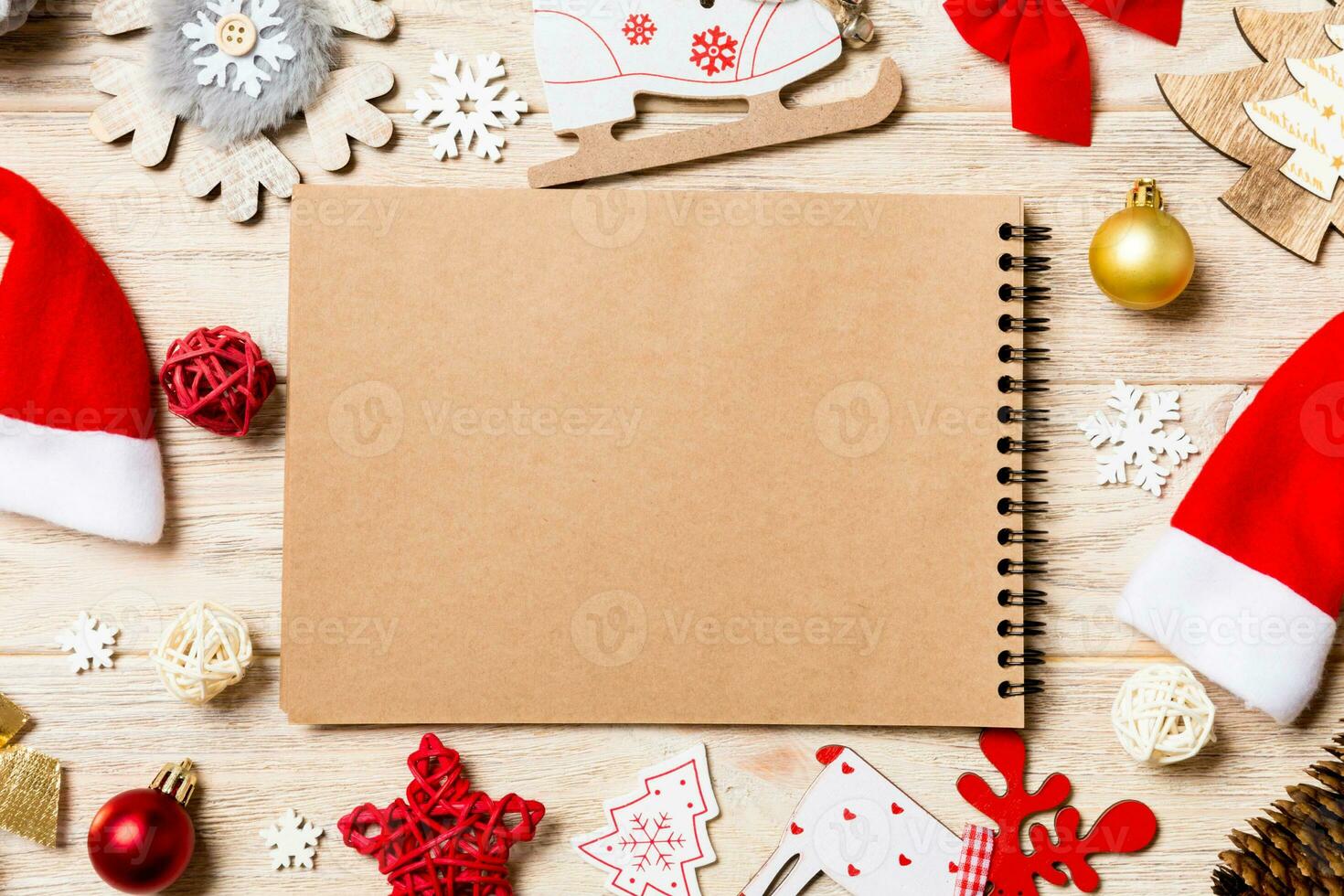 vista superior del cuaderno sobre fondo de madera hecho de adornos navideños. concepto de año nuevo foto